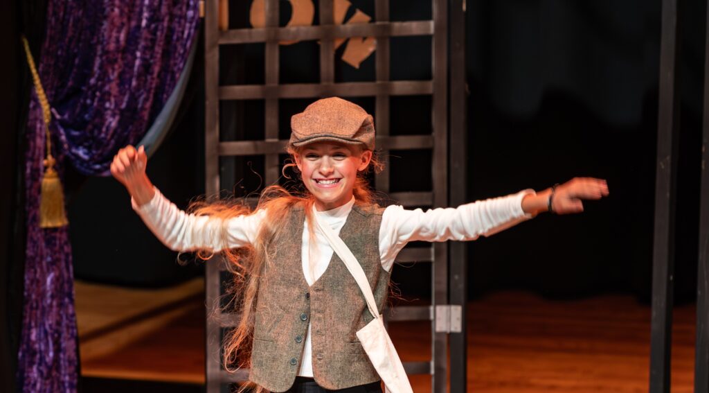 Young girl performing on stage at Woodlawn School in a costume.