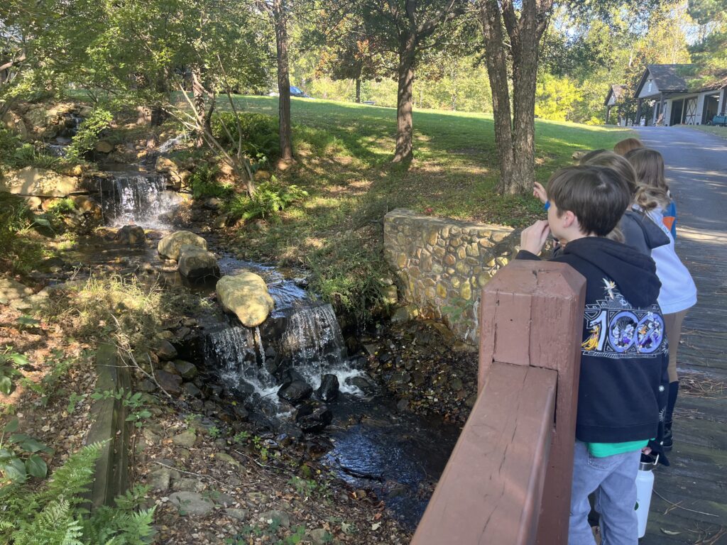 Two young Woodlawn students watching the creek that runs through campus.